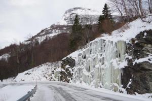 a road with ice on the side of a mountain at Lunheim in Geiranger in Geiranger
