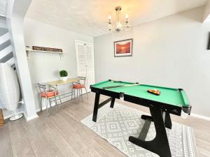 a billiard table in a living room with a table at Haven lovely home just off M20 in great area & parking in Kent