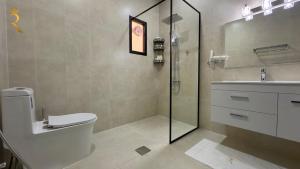 a bathroom with a shower and a toilet and a sink at Dream 5BR Villa Escape - Premium Comfort Near Corniche & Abu Dhabi City Center in Abu Dhabi +42 photos