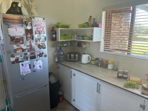 una cocina con nevera con imágenes e imanes en Karibu, en Cannon Rocks