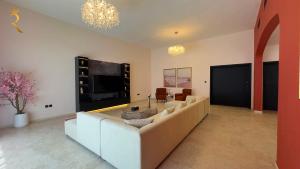 ein großes Wohnzimmer mit einem Sofa und einem TV in der Unterkunft Dream 5BR Villa Escape - Near Corniche & Abu Dhabi City Center in Abu Dhabi + 42 Fotos