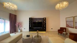uma sala de estar com um sofá e uma TV em Dream 5BR Villa Escape - Near Corniche & Abu Dhabi City Center em Abu Dhabi