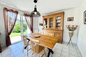 a dining room with a wooden table and chairs at Charmante maison de vacances entre bourg et plages in Ploemeur
