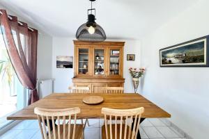 a dining room with a wooden table and chairs at Charmante maison de vacances entre bourg et plages in Ploemeur +19 photos