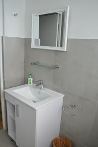 een badkamer met een witte wastafel en een spiegel bij Cherry Lane Constantia in Kaapstad
