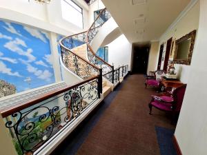 a hallway with a spiral staircase in a house at Hotel Castilla Real in Pereira