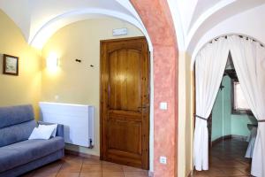 a living room with a couch and a wooden door at Allotjaments Plaça Major-Boix in Santa Pau +5 photos