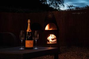 two wine bottles and glasses on a table with a fire place at Back in Thyme in Colchester