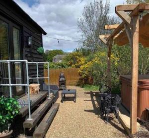a backyard with a bench and a wooden house at Back in Thyme in Colchester