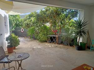 a patio with a bunch of plants and tables at Casa Vacanze Alta Marea T in Teulada +10 photos