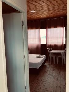 Un dormitorio con una cama y una mesa y sillas. en Pousada Pé Na Areia 1, en Peruíbe 12 fotos más