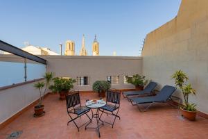 a patio with chairs and a table on a balcony at Gran Hotel Barcino in Barcelona