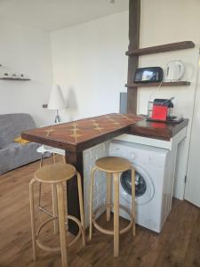 cocina con encimera, lavadora y taburetes en Appart T2 Quartier Beaujardin, en Tours