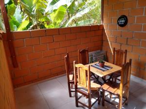 a table and chairs on a patio with a window at Chalé Quiririm in Santo Antônio do Pinhal