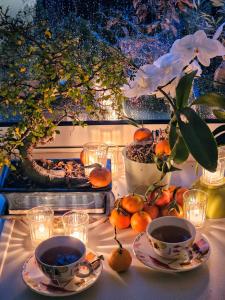 a table with two cups of tea and oranges on it at Terrasse de Malissol in Vienne +8 photos
