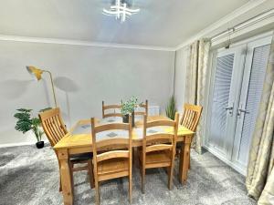 a dining room with a wooden table and chairs at Lovely modern 4 bedroom House in Ashford in Ashford
