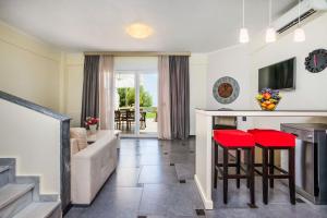 a kitchen and living room with red bar stools at Sunny Villa Epta in Hanioti
