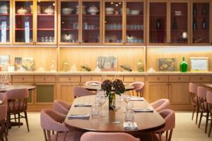 a dining room with tables and chairs and cabinets at Bellevigne Bourgogne in Chambolle-Musigny