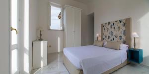 a white bedroom with a bed and a window at Hotel Crawford in Sant'Agnello