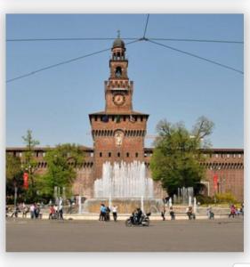 a clock tower in front of a building with a fountain at Bed and Breakfast Santa Elisa in Pero +24 photos