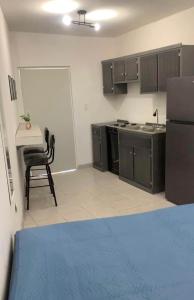 een keuken met een koelkast en een tafel met een stoel bij Apartamento Las Aldabas in Chihuahua