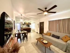 a living room with a couch and a ceiling fan at Stylish Apartments - 10 Minutes to Airport & Water Taxi, close to Best Western in Belize City
