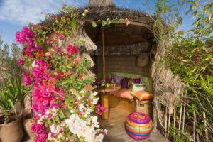 a garden room with a bed and flowers at Riad Jnane d'Ô in Marrakesh