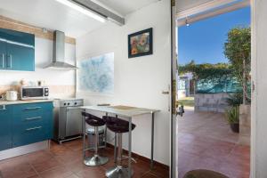 a kitchen with blue cabinets and a counter with stools at Mobile Home Manoli in Chiclana de la Frontera