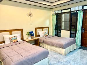 a bedroom with two beds and a window at Sea Sun Bungalow in Ko Lanta