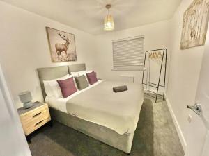 a bedroom with a large bed with purple pillows at Swindon 3 bedroom relaxing home with parking - good location for family or contractors in Swindon