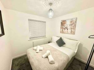 a bedroom with a bed with two towels on it at Swindon 3 bedroom relaxing home with parking - good location for family or contractors in Swindon