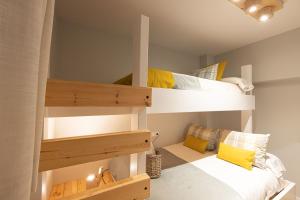 2 literas en una habitación pequeña con almohadas amarillas en SYRA junto al CARD, en Sierra Nevada