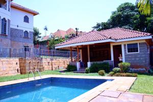 a house with a swimming pool in front of a house at Orchard Manor in Nairobi +12 photos