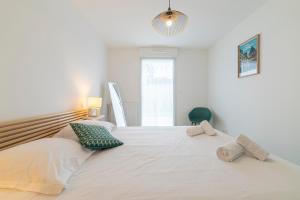 a large white bed with two pillows on it at Canon proche de la gare maritime au rdc in Vannes
