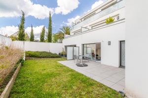 an exterior view of a white house with a yard at Canon proche de la gare maritime au rdc in Vannes