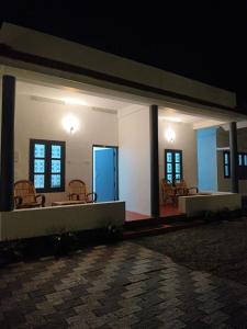 una stanza con sedie e tavoli in un edificio di notte di Kaswa Beach Resort a Varkala