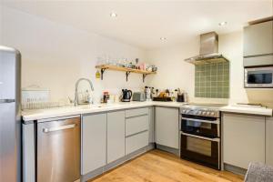 eine Küche mit weißen Schränken und Geräten aus Edelstahl in der Unterkunft Meagill Cottage Sleeps 4 with Hot Tub & Parking in Otley + 14 Fotos
