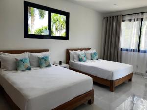une chambre avec deux lits et une fenêtre dans l'établissement Villas Montemar - Villa Sol, à Las Terrenas 21 autres photos