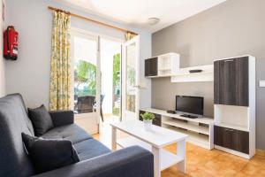 una sala de estar con un sofá y una mesa en Bungalows ses malves, en Cala en Blanes