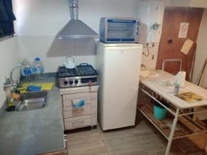 a small kitchen with a refrigerator and a stove at Montaña de Cata in Las Heras