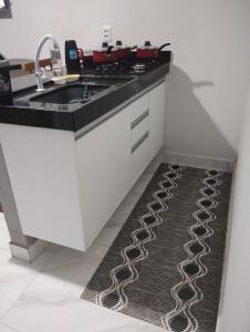 une cuisine avec un évier et un tapis de cuisine dans l'établissement Casa Loft para temporada Guarapari, à Guarapari