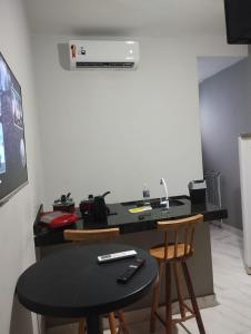 une cuisine avec une table, deux chaises et un comptoir dans l'établissement Casa Loft para temporada Guarapari, à Guarapari