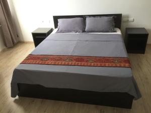 a bedroom with a large bed with two night stands at Ossanna Hotel in Yerevan