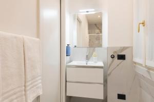 a white bathroom with a sink and a mirror at Milan Royal Suites Duomo in Milan +12 photos
