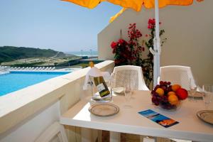 a table with a bottle of wine and a bowl of fruit at Sintra Sol - Apartamentos Turisticos in Sintra