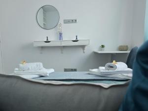 a room with a bed with a mirror and towels at The Blue Calla in Las Palmas de Gran Canaria