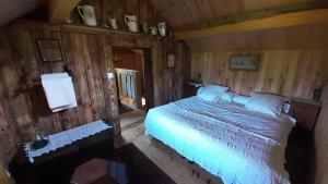 a bedroom with a bed in a wooden room at La Genotte in La Motte-dʼAveillans