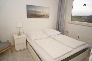 Ένα ή περισσότερα κρεβάτια σε δωμάτιο στο Penthousewohnung mit WLAN - Ostseeblick zur Sonnenseite