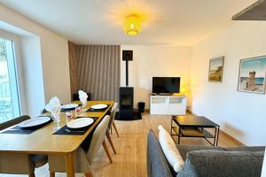 Una sala de estar con una mesa de comedor y un sofá. en Maison entièrement rénovée - À 2 pas des plages, en Ploemeur