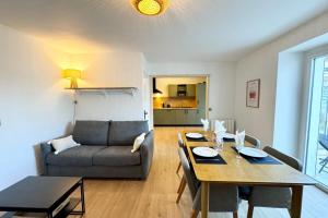 una sala de estar con una mesa y un sofá en Maison entièrement rénovée - À 2 pas des plages, en Ploemeur 17 fotos más